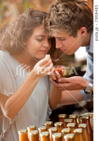 Couple tasting preserves in grocery 7908485