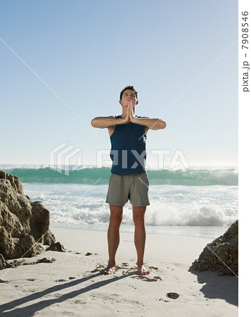 Young man doing yoga on beach 7908546