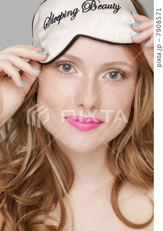 Teenage girl wearing Sleeping Beauty eye mask on head 7908571