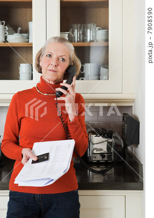 Senior woman on telephone with statement and credit card Senior woman on telephone with statement and credit card 7908590