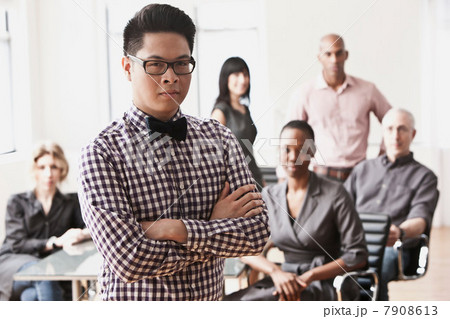 Portrait of businessman with colleagues in background Portrait of businessman with colleagues in background 7908613