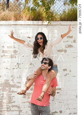 Young man with young woman on shoulders 7908724