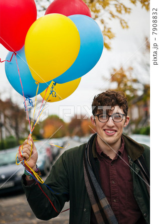 Young man holding colourful balloons, portrait Young man holding colourful balloons, portrait 7908832