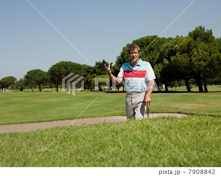 Man playing golf, stuck in bunker 7908842
