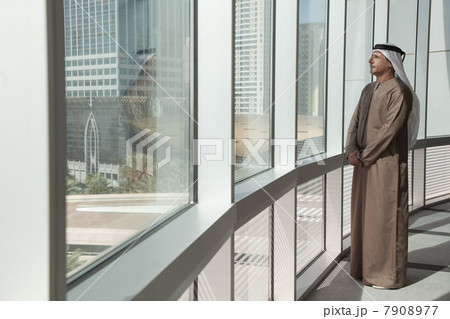 Middle eastern businessman looking out of office window 7908977