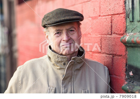 Portrait of senior man leaning on red brick wall Portrait of senior man leaning on red brick wall 7909018