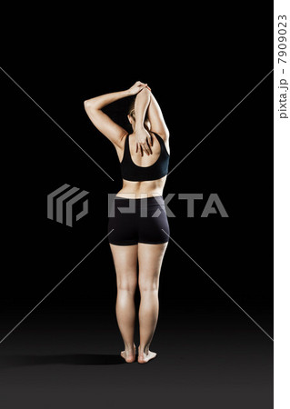 Athlete stretching, rear view Athlete stretching, rear view 7909023