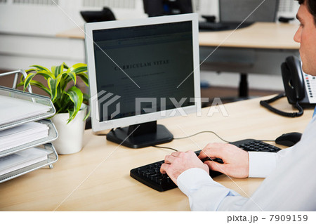 Office worker using computer to update resume 7909159