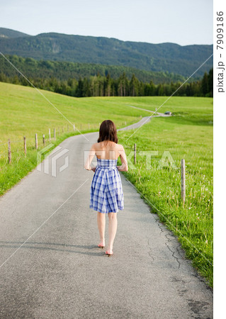 Woman walking on country lane, Bavaria, Germany Woman walking on country lane, Bavaria, Germany 7909186