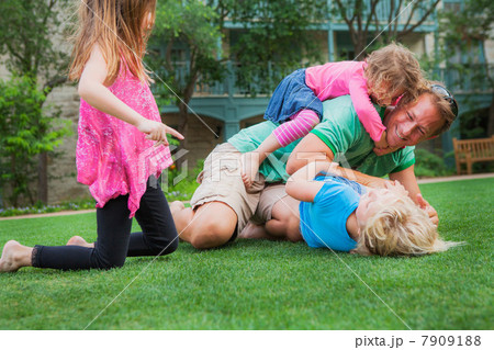 Father playing with his daughters in garden Father playing with his daughters in garden 7909188