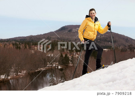 Young woman in skis walking uphill 7909218