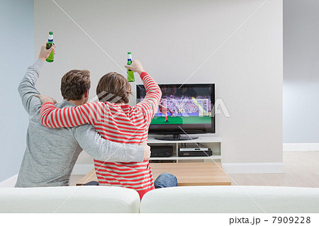 Two young men watching football on television Two young men watching football on television 7909228