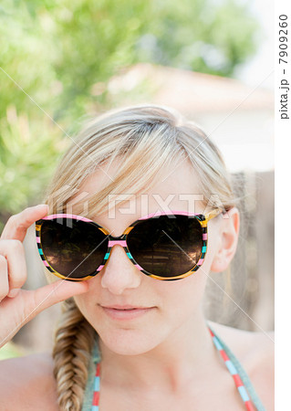 Young woman with blond hair wearing sunglasses 7909260