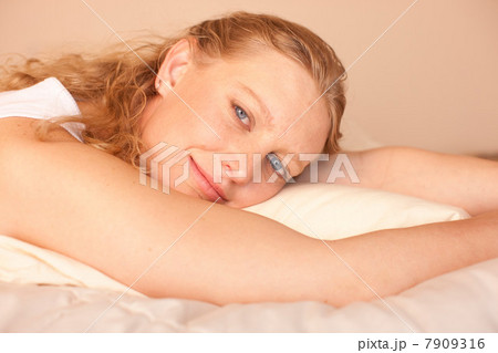 Mid adult woman relaxing on bed, portrait 7909316