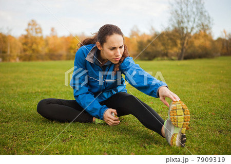 Young woman performing stretches in park 7909319
