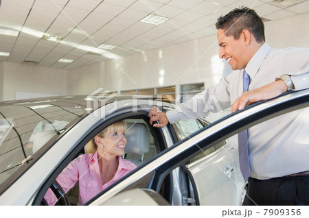 Woman in drivers seat of new car at car dealership 7909356