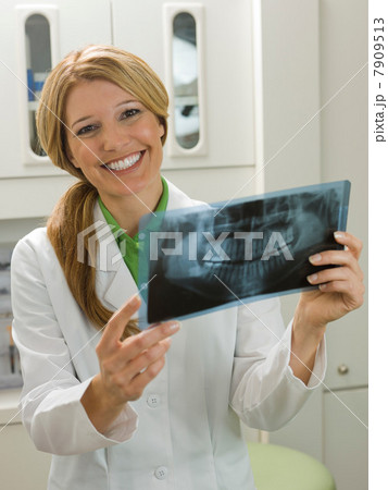Dentist looking at x-ray, smiling Dentist looking at x-ray, smiling 7909513