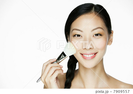 Young woman using makeup brush 7909557