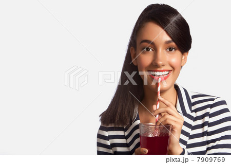 Young woman in striped top drinking from straw against white background 7909769