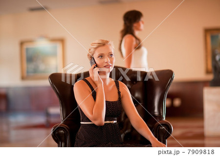 Woman talking on cell phone in lobby Woman talking on cell phone in lobby 7909818