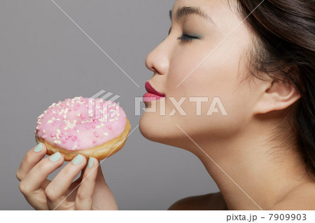 Young woman holding doughnut Young woman holding doughnut 7909903