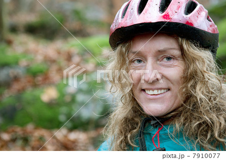 Mature woman wearing cycling helmet in forest 7910077