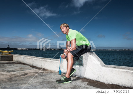 Young man in sportswear resting on pier 7910212