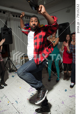 Man wearing checked shirt dancing at party 7910232