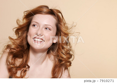 Studio shot of young woman with curly red hair Studio shot of young woman with curly red hair 7910271