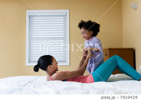 Mother and daughter playing on bed Mother and daughter playing on bed 7910429
