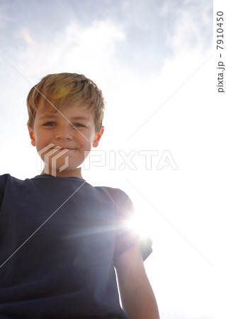 Low angle view of boy in sunlight Low angle view of boy in sunlight 7910450
