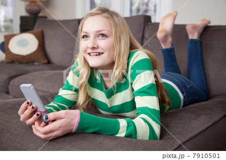Girl lying on front using smartphone Girl lying on front using smartphone 7910501