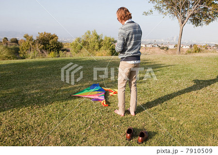Young man in field with kite Young man in field with kite 7910509
