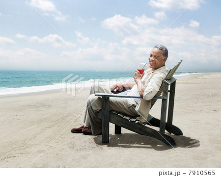 Mature man relaxing in chair on beach 7910565