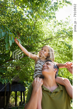 Father carrying daughter on shoulders 7910602