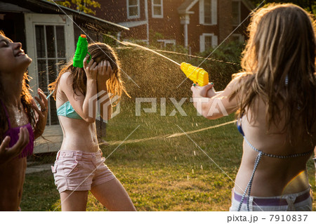 Girls having water fight with water pistols 7910837