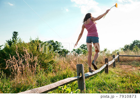 Teenage girl balancing on wooden fence Teenage girl balancing on wooden fence 7910873