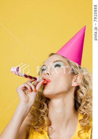 Young woman wearing party hat with party blower 7910888