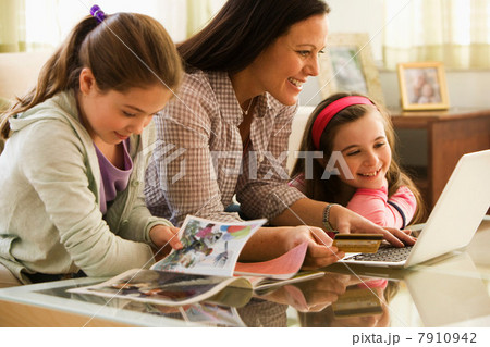Mother and two daughters using laptop at home 7910942