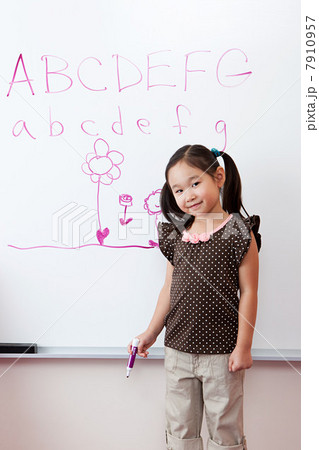 Girl in front of whiteboard with alphabet 7910957