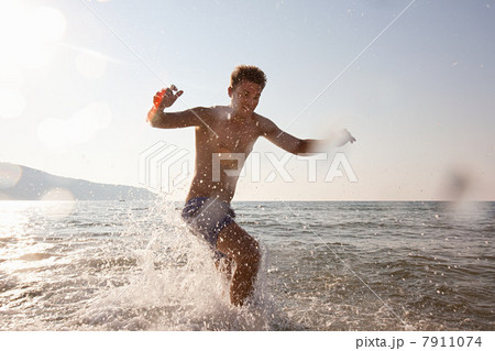 Young man splashing in sea 7911074