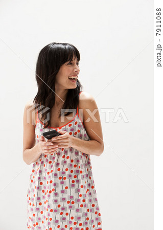 Smiling mature woman using cellphone, studio shot 7911088