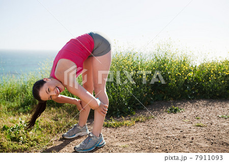 Young woman bending over to stretch 7911093