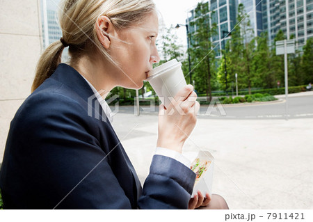 Businesswoman with coffee and sandwiches 7911421