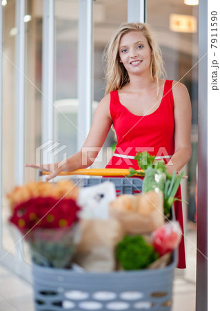 Woman pushing shopping cart Woman pushing shopping cart 7911590