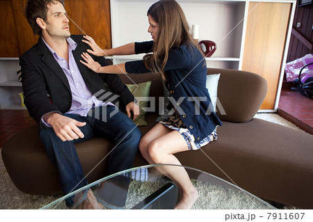 Couple sitting on sofa, woman pushing man away 7911607