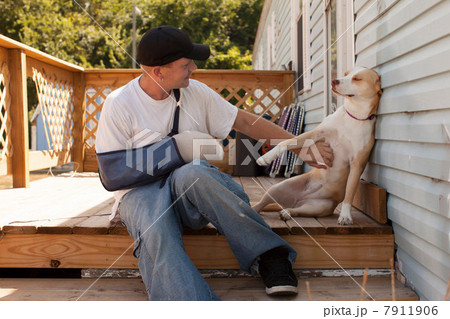 Man outside house with arm in sling and dog Man outside house with arm in sling and dog 7911906