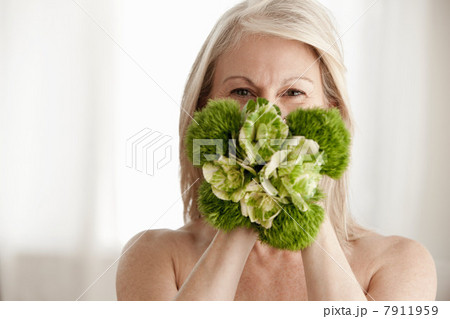 Mature woman holding plant, portrait 7911959
