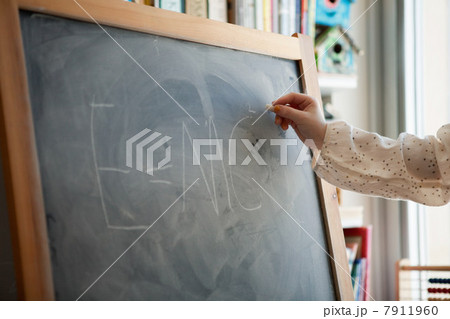 Girl writing E=MC2 on blackboard 7911960
