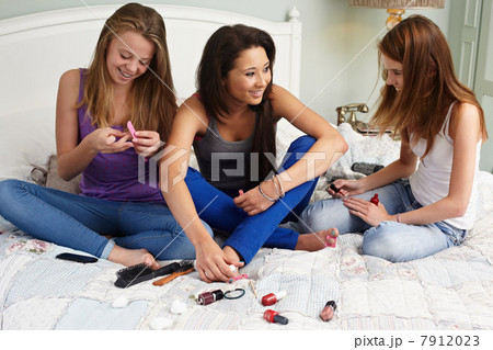 Teenage girls using nail polishes 7912023